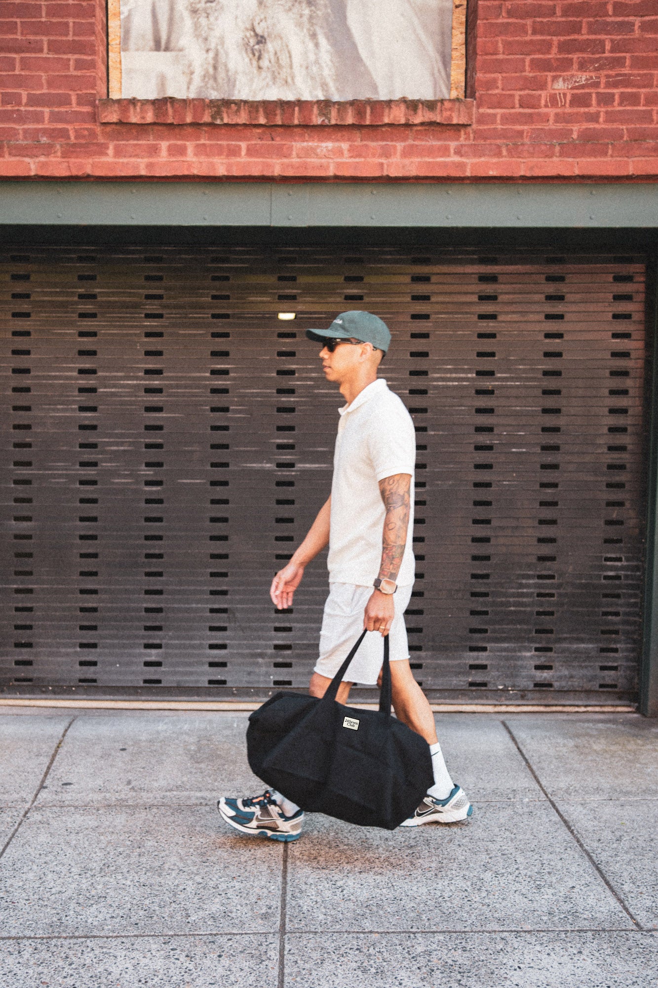 Man walking with black duffle bag 24 seven club
