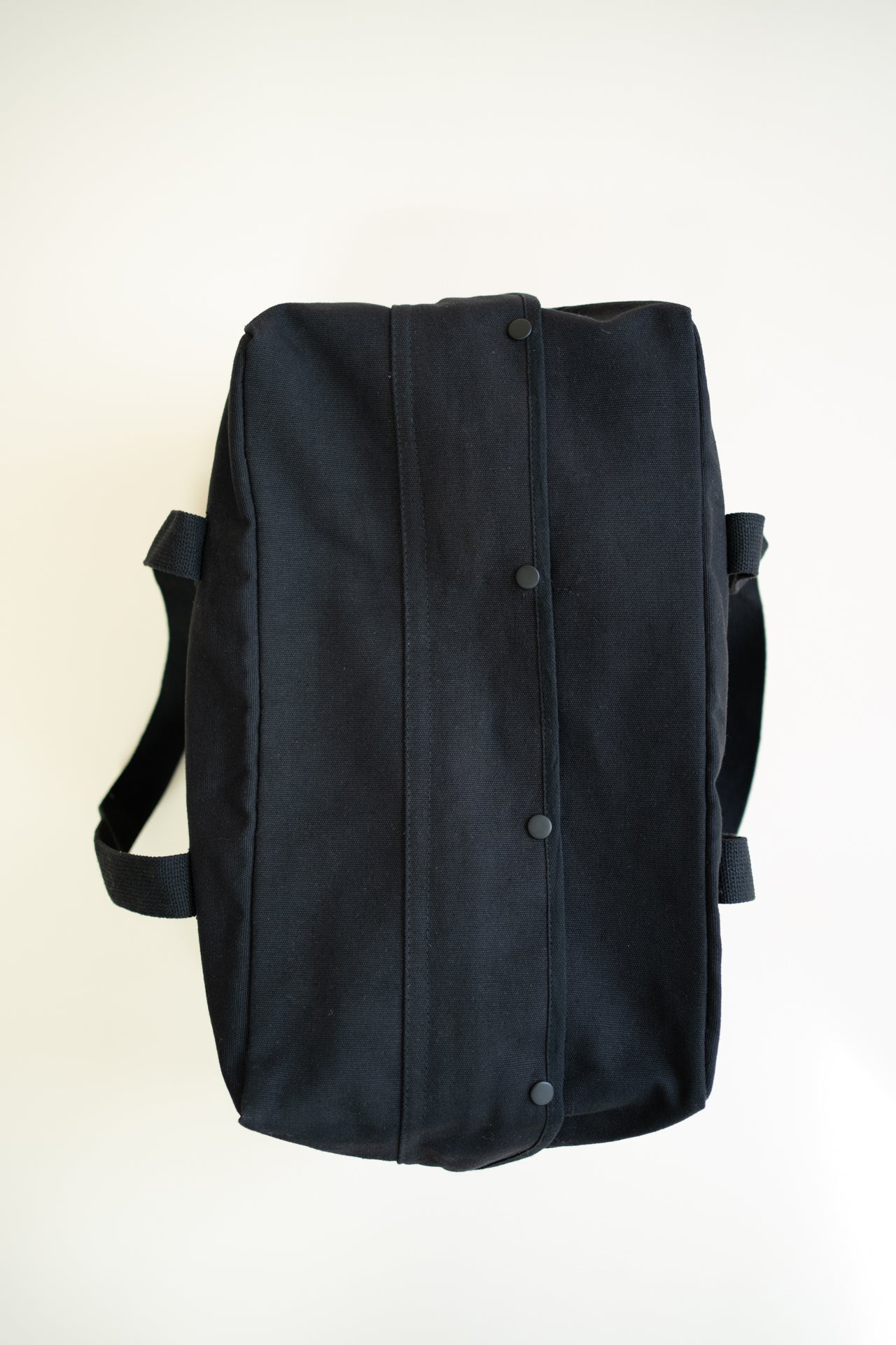 Black canvas duffle bag with 24 seven club logo on a patch