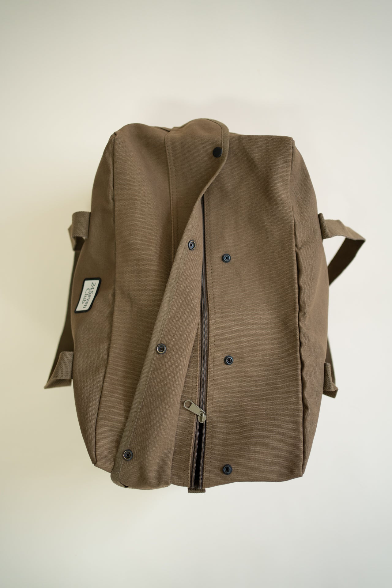 Brown canvas duffle bag with 24 seven club logo on a patch