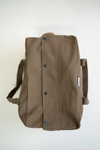 Brown canvas duffle bag with 24 seven club logo on a patch