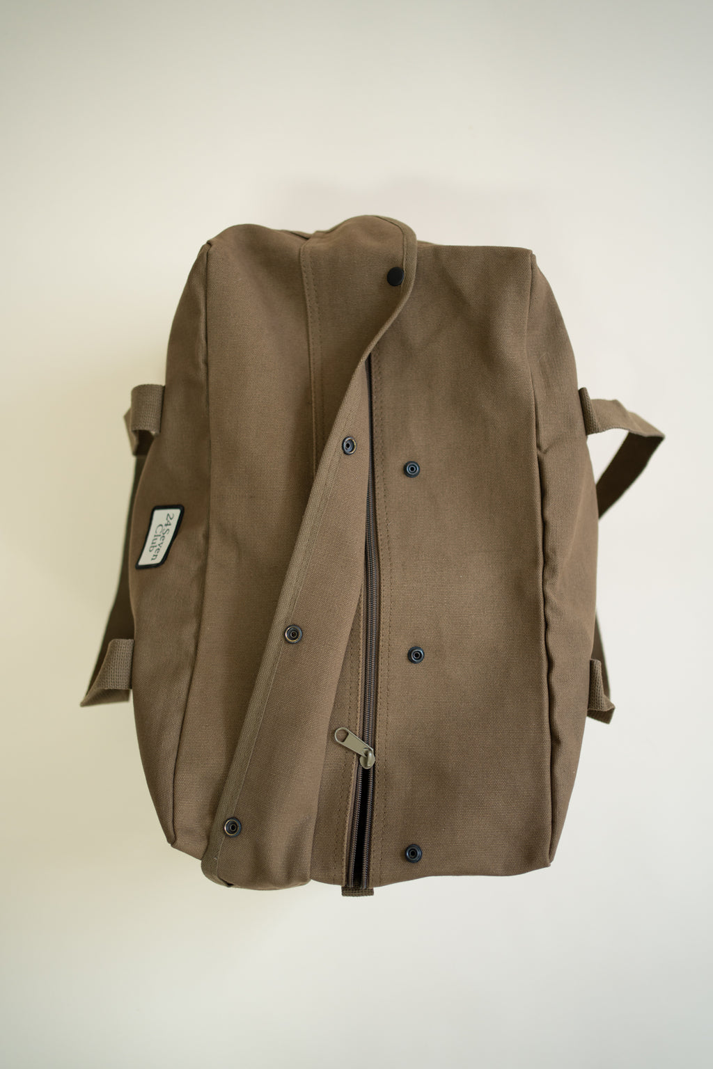 Brown canvas duffle bag with 24 seven club logo on a patch