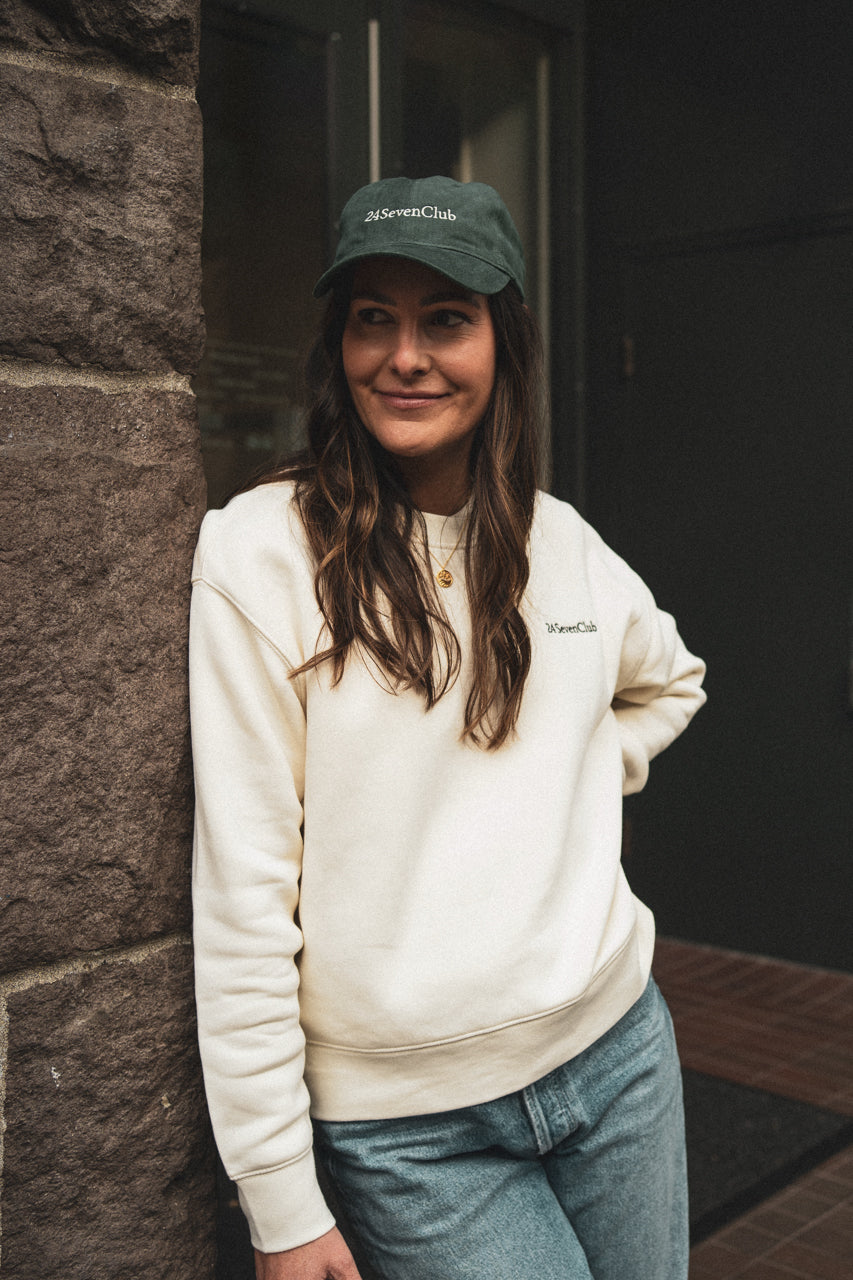 Entrepreneur wearing an embroidered 24 seven club cream crewneck sweatshirt and hat