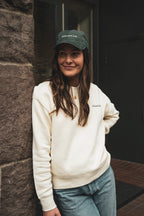 Entrepreneur wearing an embroidered 24 seven club cream crewneck sweatshirt and hat