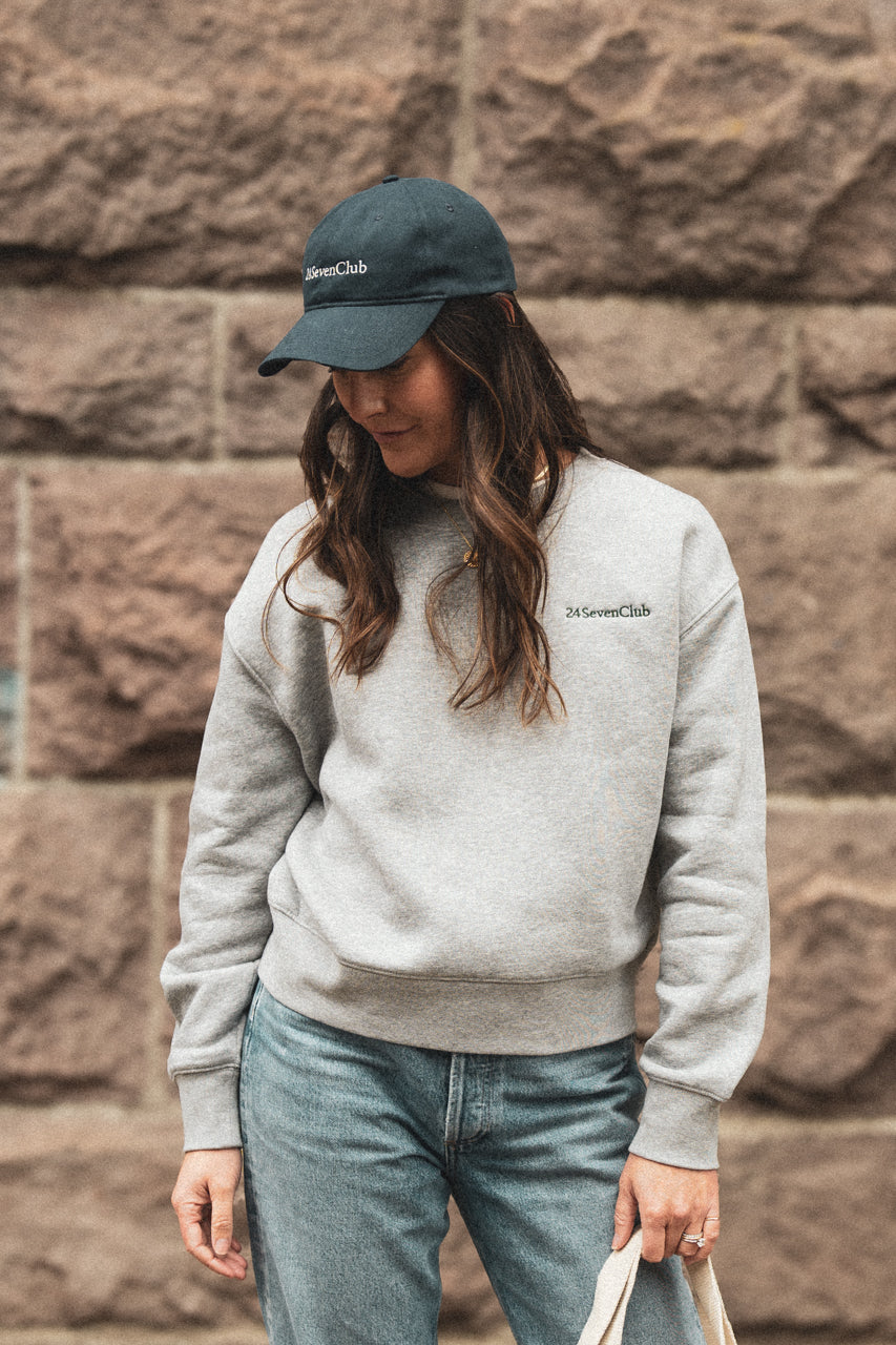 Entrepreneur wearing a 24 seven club heather grey crewneck sweatshirt and hat