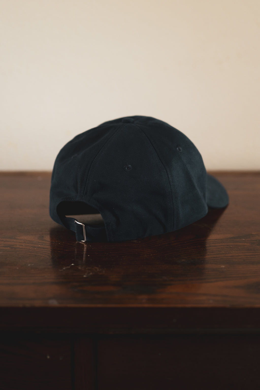 Navy cap with '24 Seven Club' embroidered logo on a wooden surface