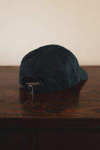 Navy cap with '24 Seven Club' embroidered logo on a wooden surface